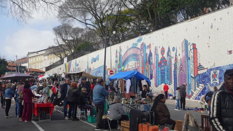 Flohmarktstände vor einer künstlerisch gestalteten Wand