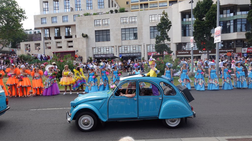 Tanzgruppen in farbenfrohen Kostümen begleiten die Oldtimer Auto Parade.