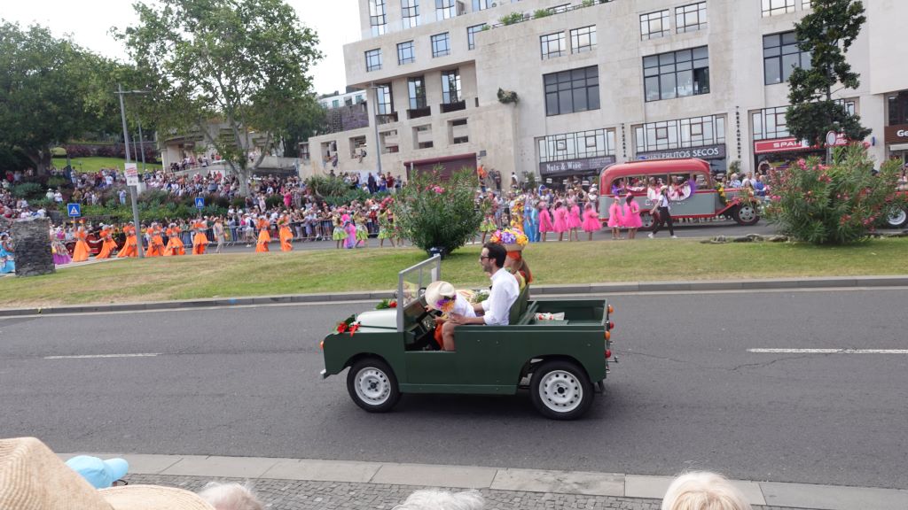 Tanzgruppen in farbenfrohen Kostümen begleiten die Oldtimer Auto Parade.