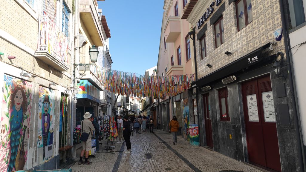 schmale Straße mit Läden und Kunstwerken an den Außenwänden