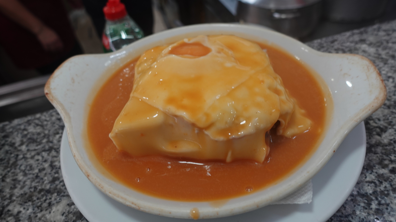 Franceshina, ein kalorienreiches Sandwich, gefüllt mit mehreren Schichten Fleisch, umhüllt mit viel Käse, einem Spiegelei obenauf und einer geheimnisvollen Sauce.