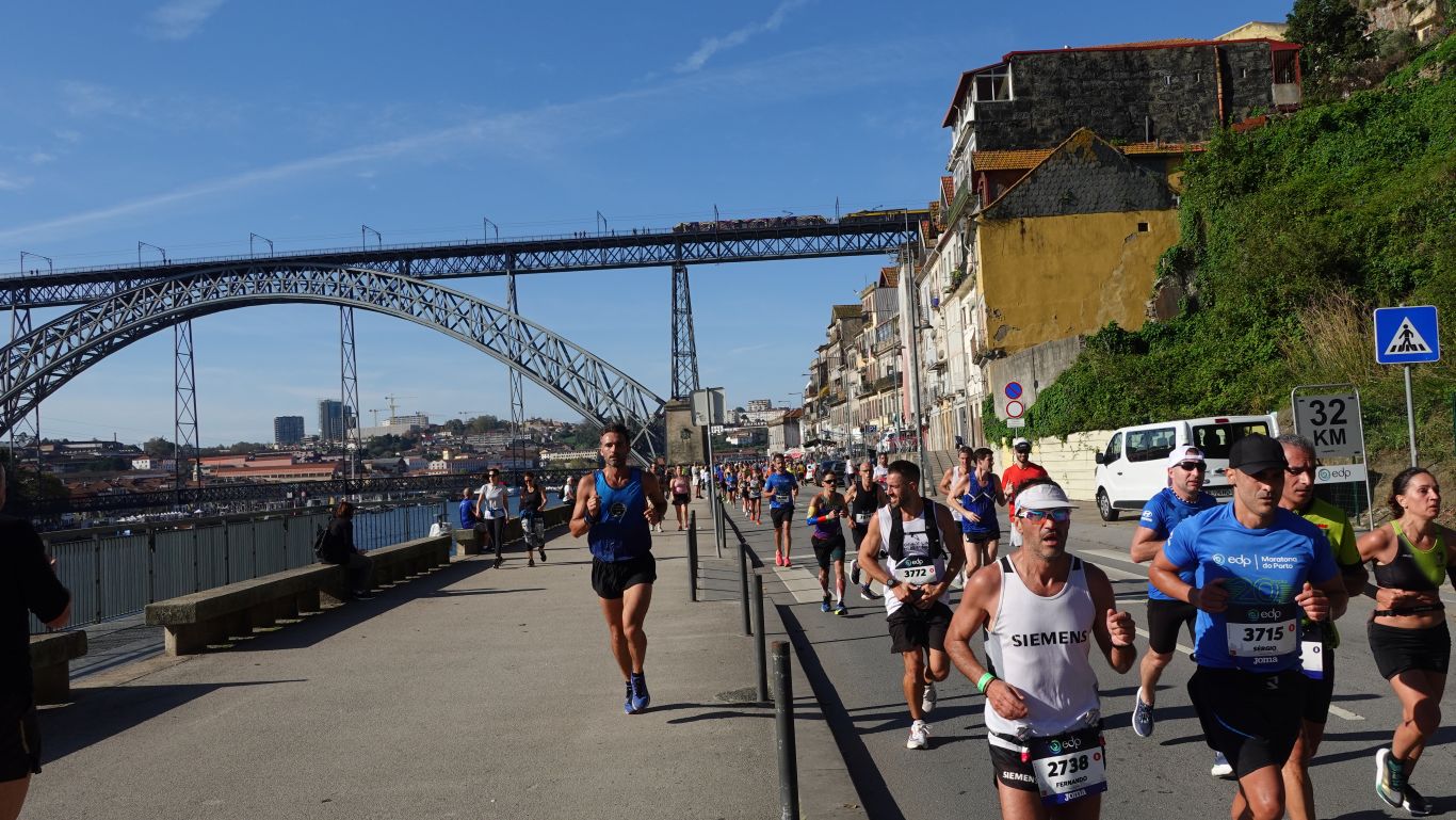 Porto-Marathon 2024: Läufer am Douroufer - im Hintergrund eine Stahlbrücke