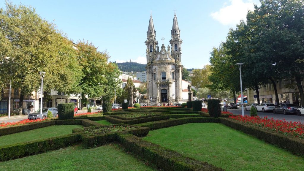 Guimarᾶes: So erlebst du portugiesische Geschichte pur - Blick über Parkanlagen hinweg auf eine Kirche mit zwei Türmen